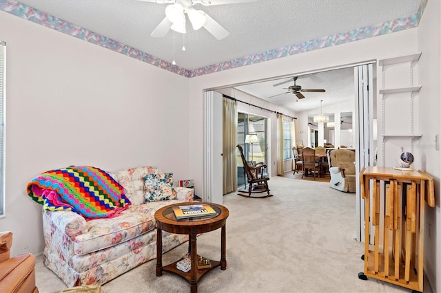 carpeted living room with ceiling fan and a textured ceiling