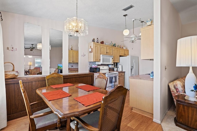 dining room with light wood-type flooring, a textured ceiling, and ceiling fan