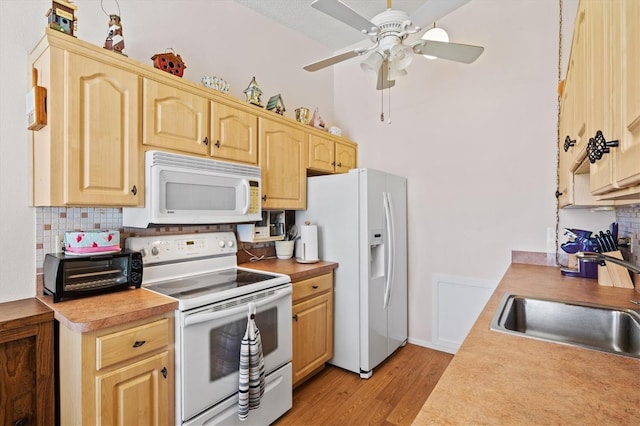 kitchen with light brown cabinetry, sink, decorative backsplash, white appliances, and light wood-type flooring