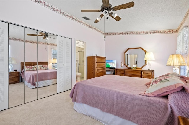 bedroom featuring ceiling fan, light carpet, a closet, and a textured ceiling