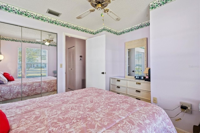 bedroom with ceiling fan, a closet, and a textured ceiling