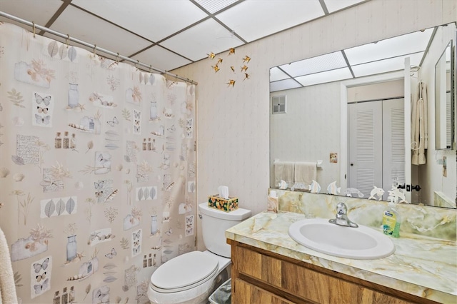 bathroom with vanity, a paneled ceiling, a shower with shower curtain, and toilet