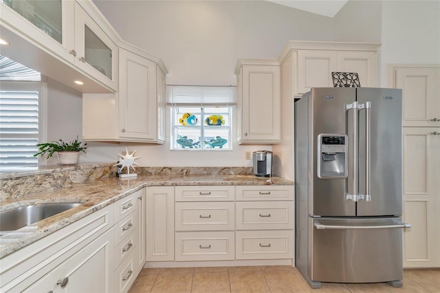 kitchen featuring light stone counters, white cabinetry, and high end refrigerator