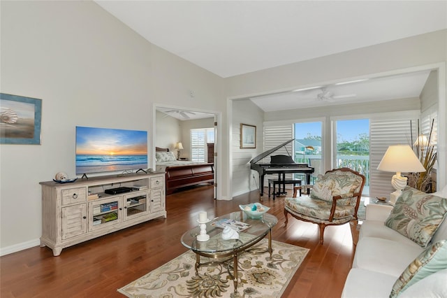 living room featuring vaulted ceiling, dark wood-type flooring, and ceiling fan