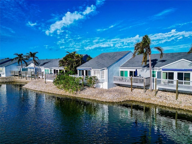 back of property featuring a deck with water view