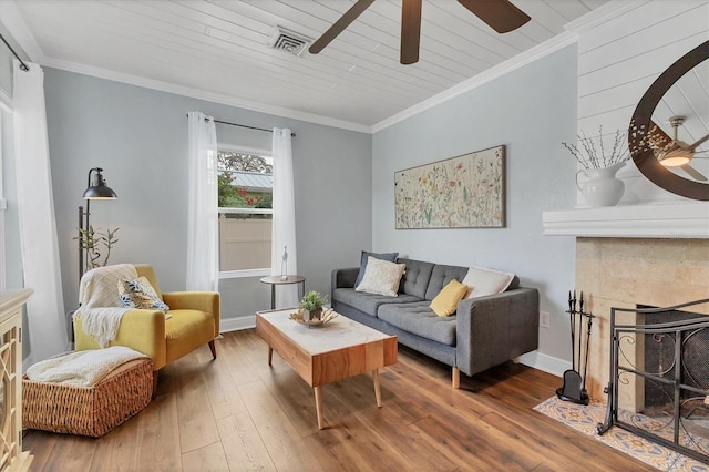 living room with crown molding, hardwood / wood-style floors, wood ceiling, and a tile fireplace