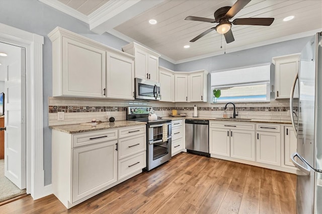 kitchen featuring sink, stainless steel appliances, tasteful backsplash, light stone countertops, and beamed ceiling