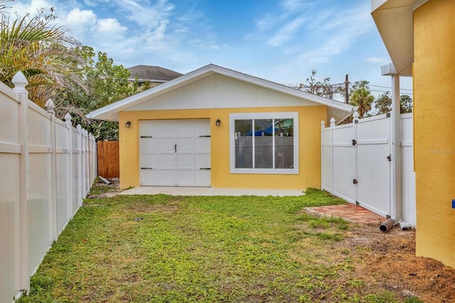 exterior space with a garage, an outdoor structure, and a lawn