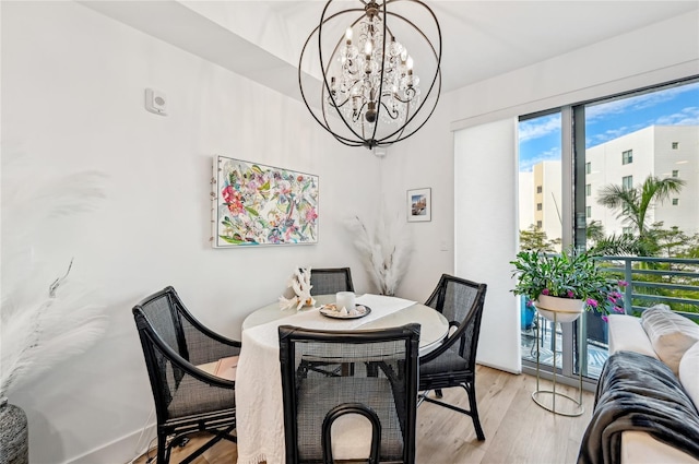 dining room with light hardwood / wood-style floors and a chandelier