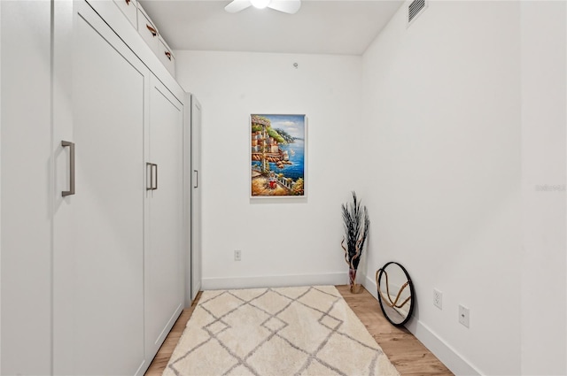 interior space with light wood-type flooring, ceiling fan, and a closet