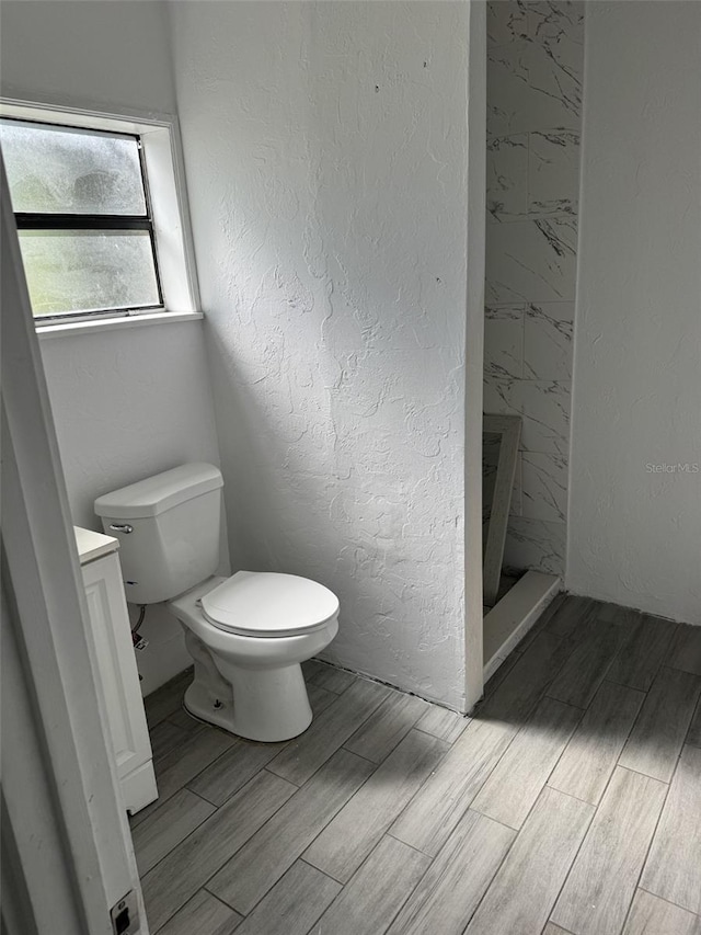 bathroom featuring vanity, toilet, and a shower