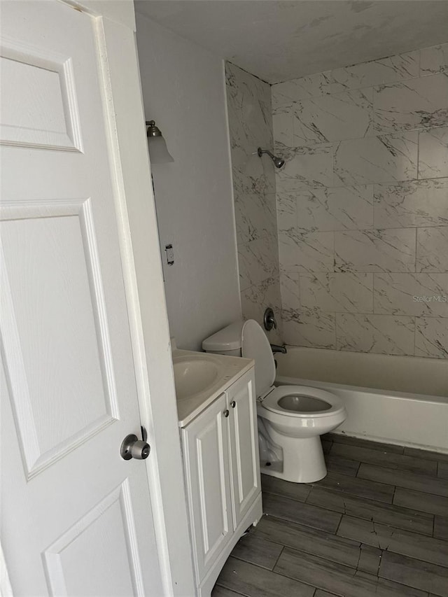 full bathroom featuring vanity, tiled shower / bath combo, and toilet