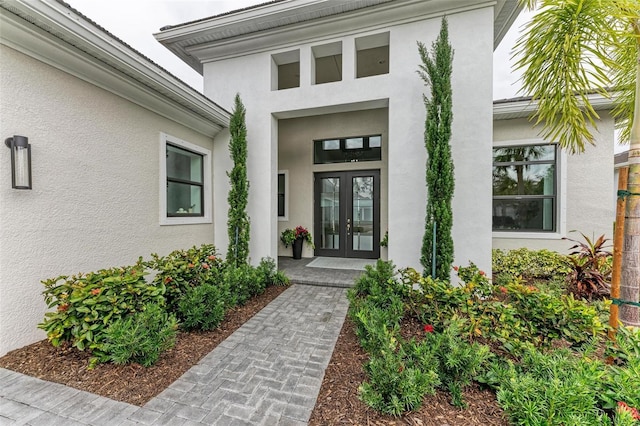 view of exterior entry with french doors and stucco siding