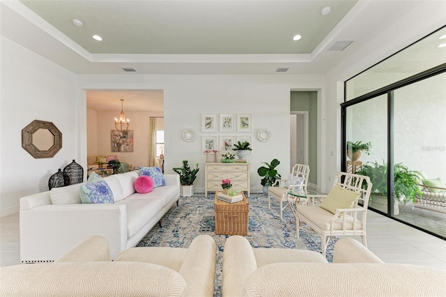 living room with an inviting chandelier and a tray ceiling