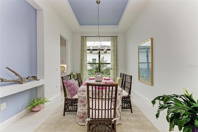 dining area featuring a notable chandelier and a tray ceiling