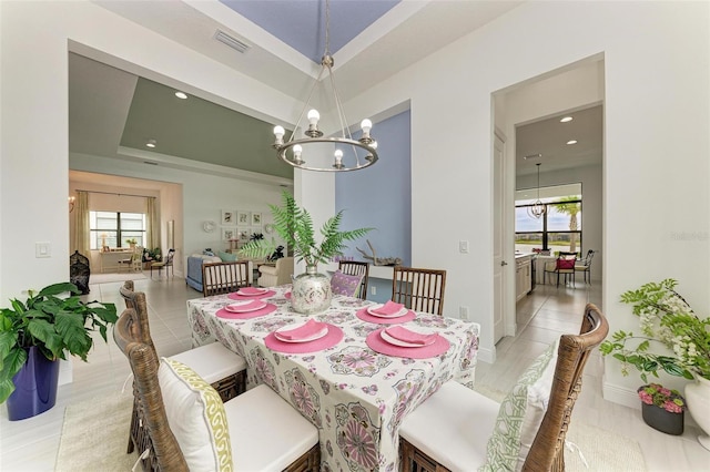 dining space with visible vents, baseboards, a chandelier, a tray ceiling, and recessed lighting