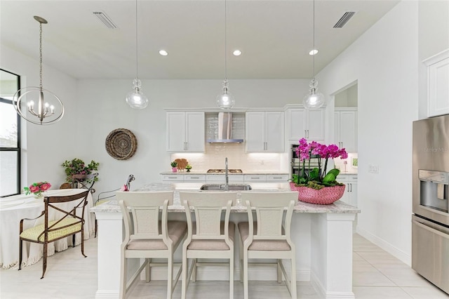 kitchen featuring white cabinetry, a center island with sink, wall chimney exhaust hood, and stainless steel fridge with ice dispenser