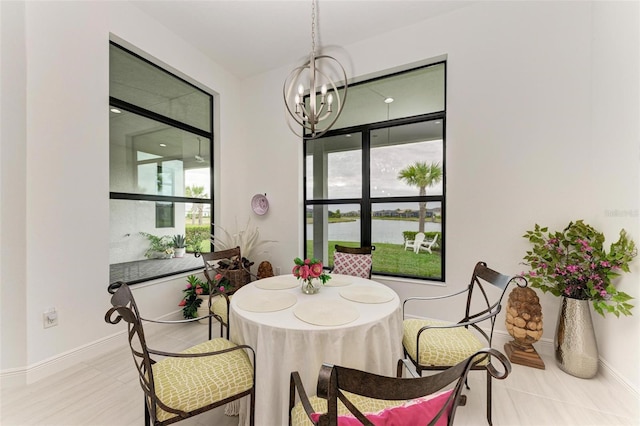 dining space featuring baseboards and a chandelier