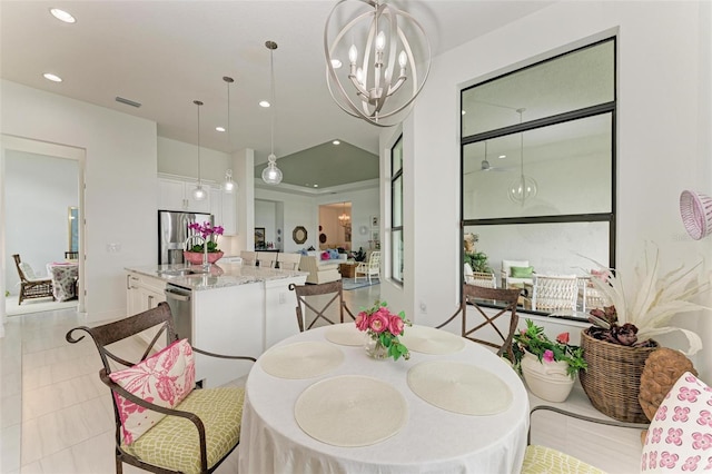 dining area with lofted ceiling and an inviting chandelier