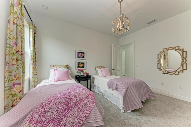 carpeted bedroom featuring an inviting chandelier