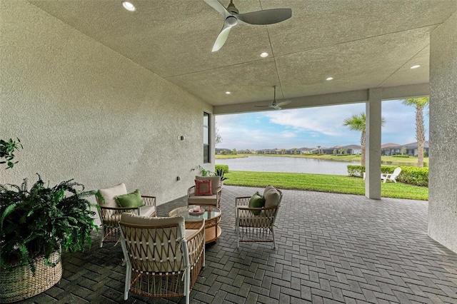 view of patio / terrace with a water view, ceiling fan, and outdoor lounge area