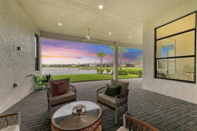 patio terrace at dusk with a water view and an outdoor hangout area