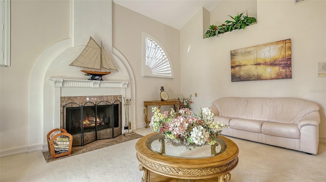 carpeted living room with high vaulted ceiling, visible vents, and a premium fireplace