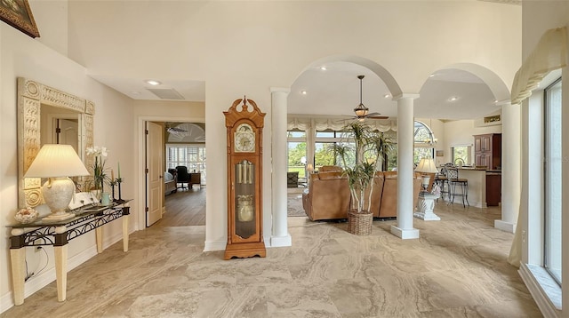 interior space with arched walkways, marble finish floor, decorative columns, a towering ceiling, and ceiling fan