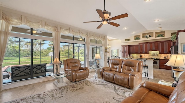 living area with ceiling fan, high vaulted ceiling, and light tile patterned floors