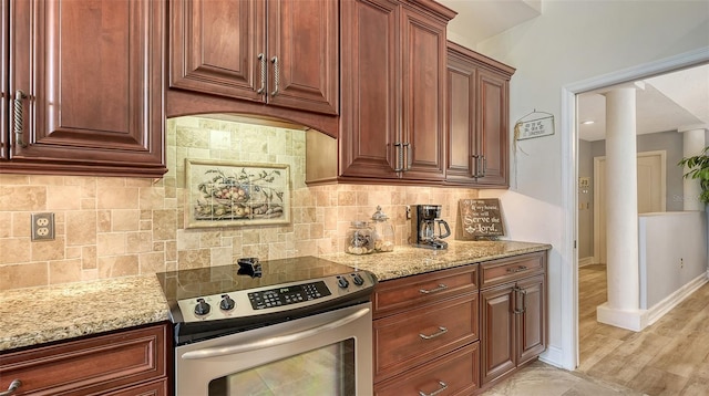 kitchen with light stone counters, electric stove, backsplash, and baseboards