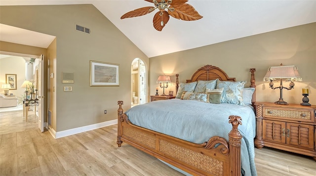 bedroom featuring arched walkways, ensuite bathroom, light wood-style flooring, visible vents, and baseboards