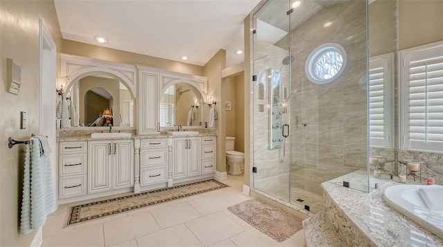 full bath featuring toilet, a stall shower, a sink, and a bath