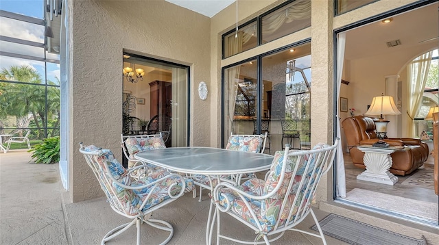 view of patio with glass enclosure and visible vents