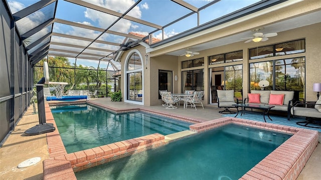 view of pool with a ceiling fan, a patio, glass enclosure, a pool with connected hot tub, and an outdoor living space