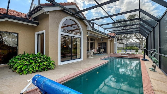 pool with a patio area, glass enclosure, a ceiling fan, and an in ground hot tub