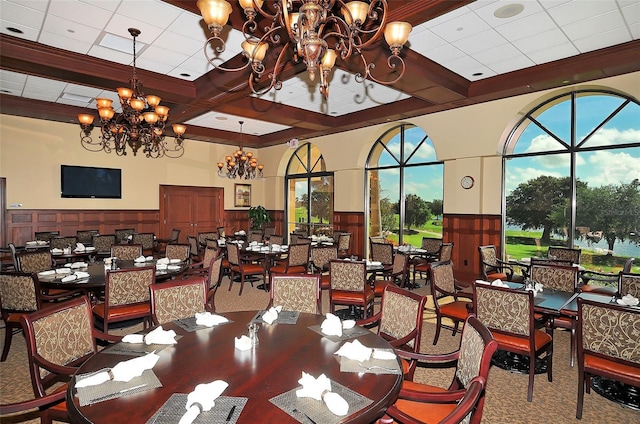 dining area featuring a chandelier, a wainscoted wall, and beamed ceiling