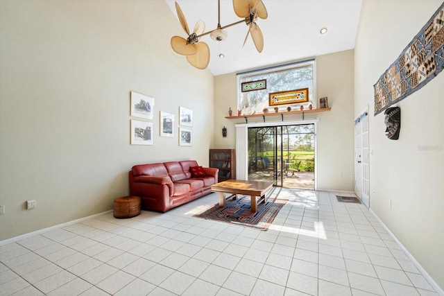 living room featuring light tile patterned floors, ceiling fan, and a high ceiling