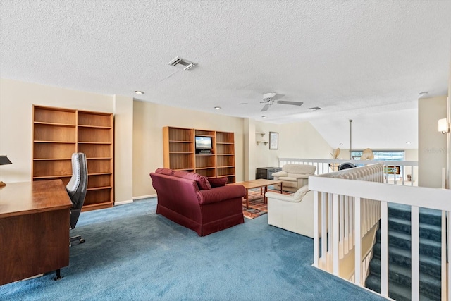 carpeted living room with ceiling fan and a textured ceiling