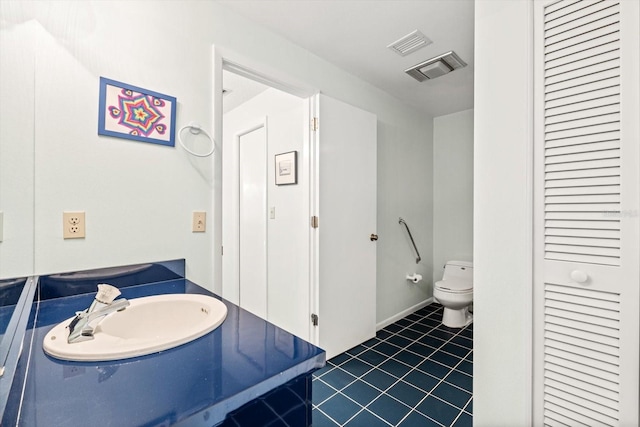 bathroom featuring sink, tile patterned floors, and toilet