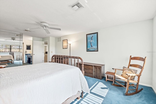 bedroom with ceiling fan, carpet, and a textured ceiling