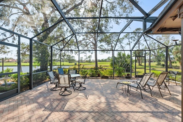 view of patio with a water view and a lanai