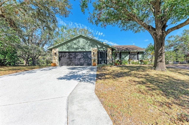 ranch-style house featuring a garage and a front lawn