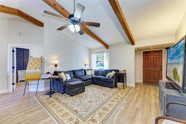 living room with light hardwood / wood-style flooring, lofted ceiling with beams, and a textured ceiling