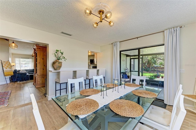 dining room with light hardwood / wood-style flooring and a textured ceiling