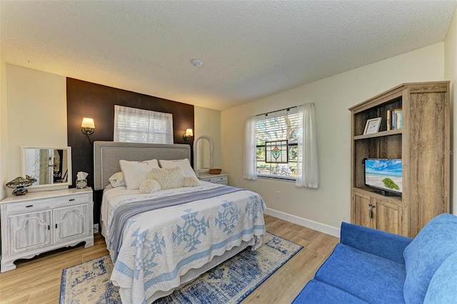 bedroom featuring a textured ceiling and light wood-type flooring