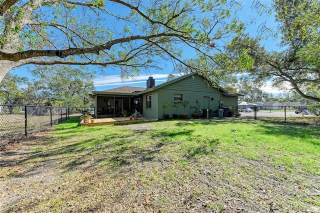 rear view of property featuring a deck, a lawn, and central air condition unit