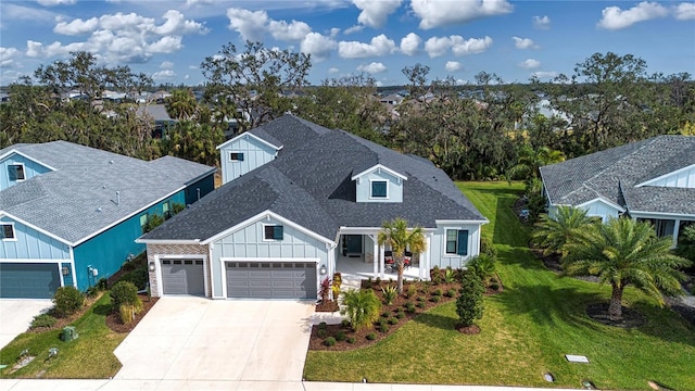 view of front facade featuring a garage, a front lawn, and a porch