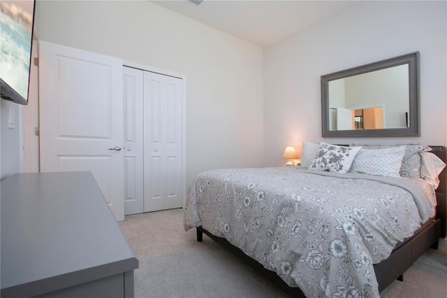 bedroom featuring light colored carpet and a closet