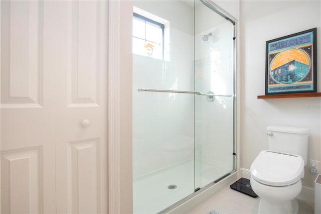 bathroom with a shower with door, tile patterned floors, and toilet