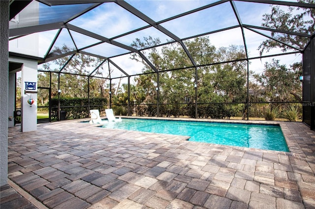 view of swimming pool with a patio, pool water feature, and glass enclosure